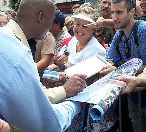 John signs autographs